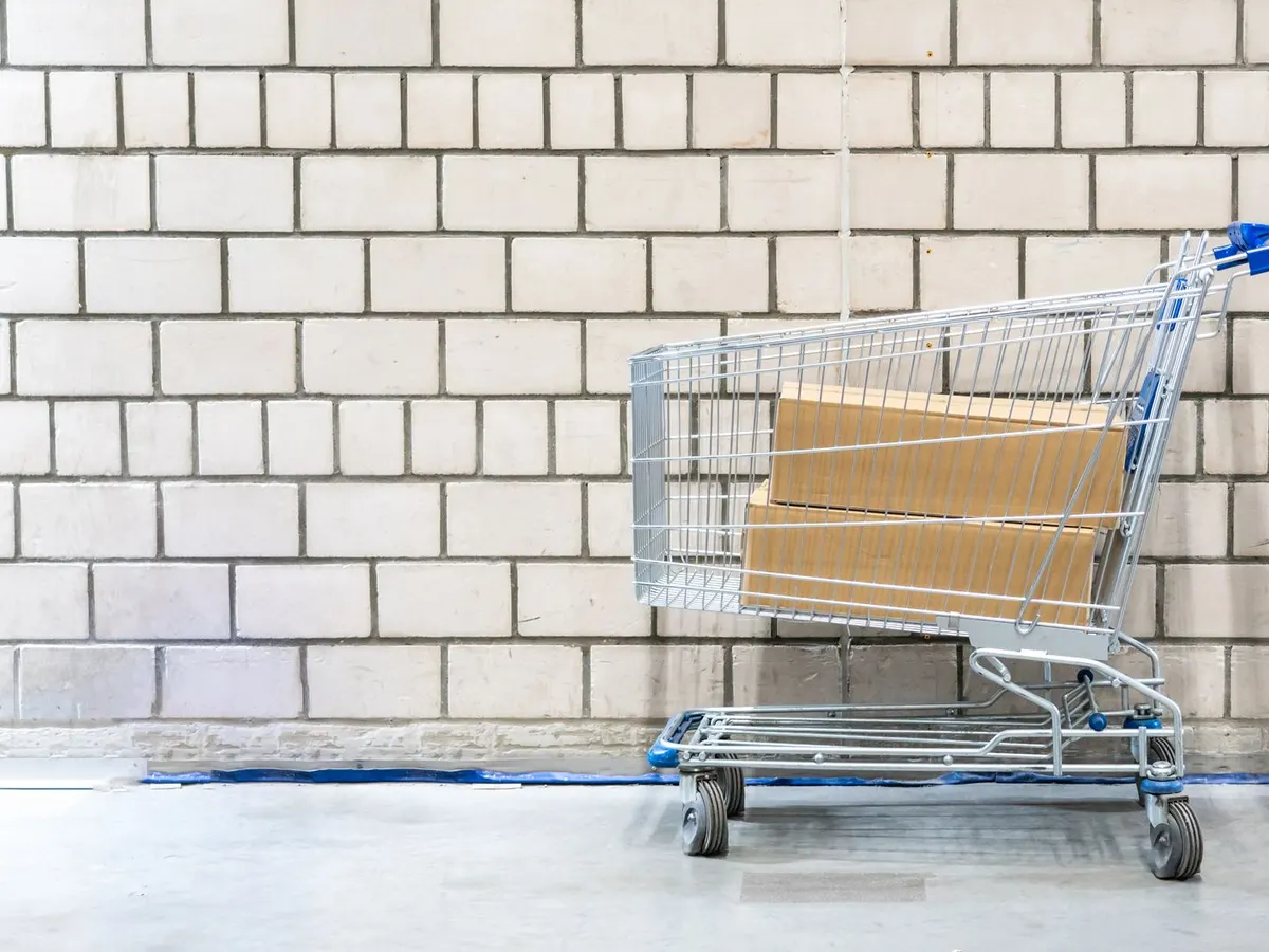 Cash and carry trolley, 6 wheel stock trolley and zinc plated roll cage lined up in a wholesaler aisle